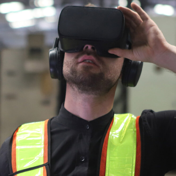 Engineer in a VR headset and vest providing services in human factors engineering